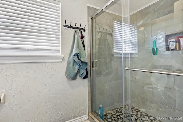 bathroom featuring plenty of natural light and walk in shower