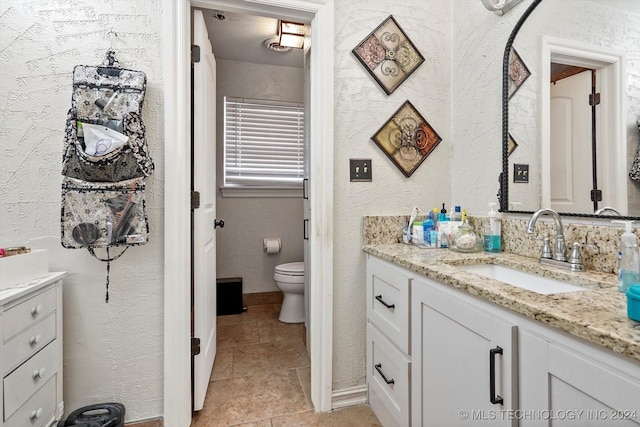 bathroom featuring tile patterned flooring, vanity, and toilet