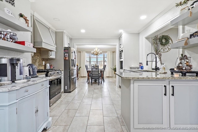 kitchen with light stone countertops, stainless steel appliances, a chandelier, white cabinets, and custom exhaust hood