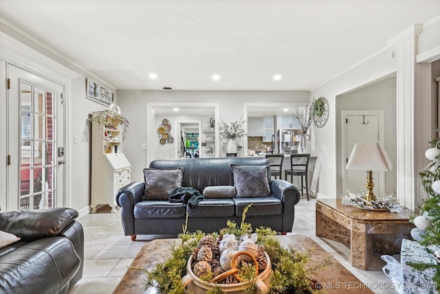 living room with crown molding and light tile patterned flooring