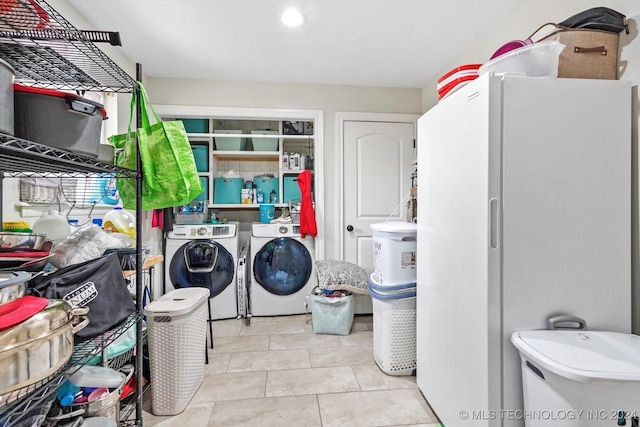 laundry area featuring washer and clothes dryer and light tile patterned flooring