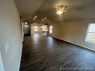 unfurnished living room featuring ceiling fan, dark hardwood / wood-style flooring, and vaulted ceiling