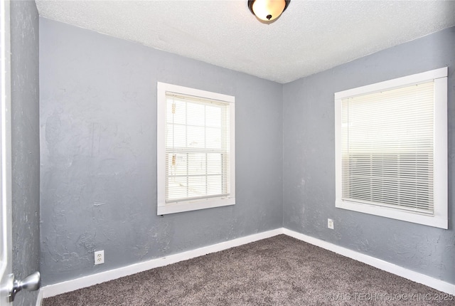 carpeted spare room featuring a textured ceiling