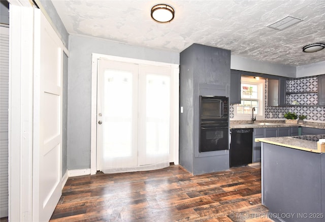 kitchen featuring black appliances, decorative backsplash, gray cabinetry, sink, and dark hardwood / wood-style flooring