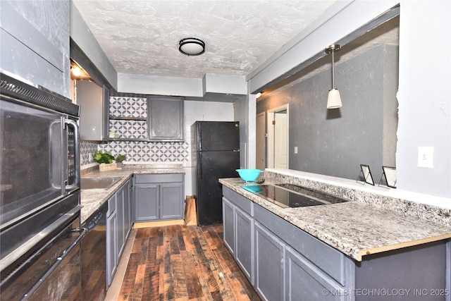 kitchen featuring hanging light fixtures, dark wood-type flooring, gray cabinetry, a textured ceiling, and black appliances