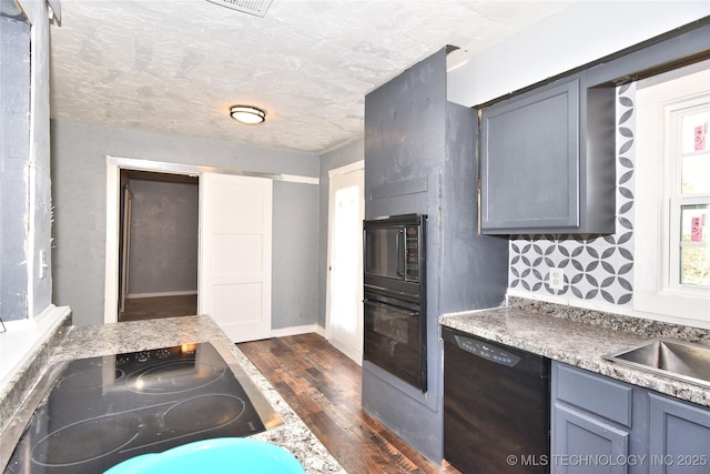 kitchen with black appliances, dark wood-type flooring, a textured ceiling, and gray cabinets