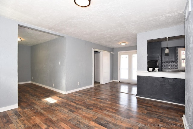 unfurnished living room featuring dark hardwood / wood-style floors and a textured ceiling