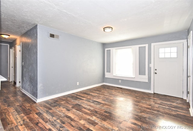 foyer entrance featuring dark wood-type flooring and a textured ceiling