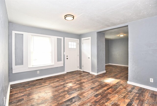 foyer featuring dark wood-type flooring and a textured ceiling