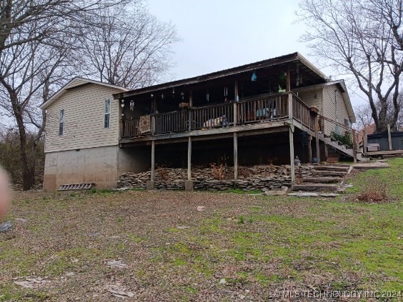 rear view of house featuring a wooden deck