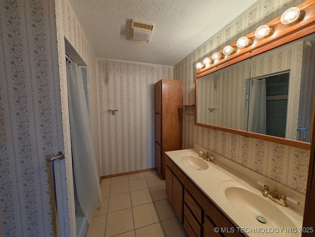 full bathroom with wallpapered walls, a textured ceiling, and a sink