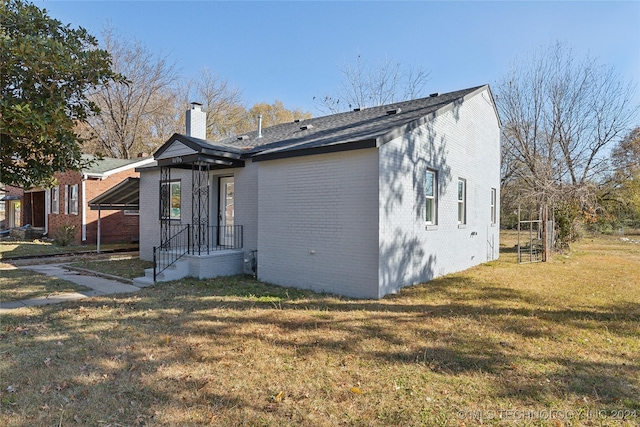 view of front of home with a front yard and a carport