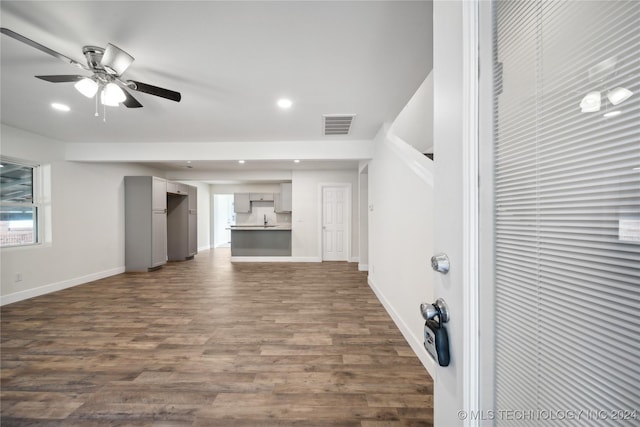 unfurnished living room featuring dark hardwood / wood-style floors and ceiling fan