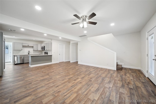 unfurnished living room featuring ceiling fan and dark hardwood / wood-style flooring