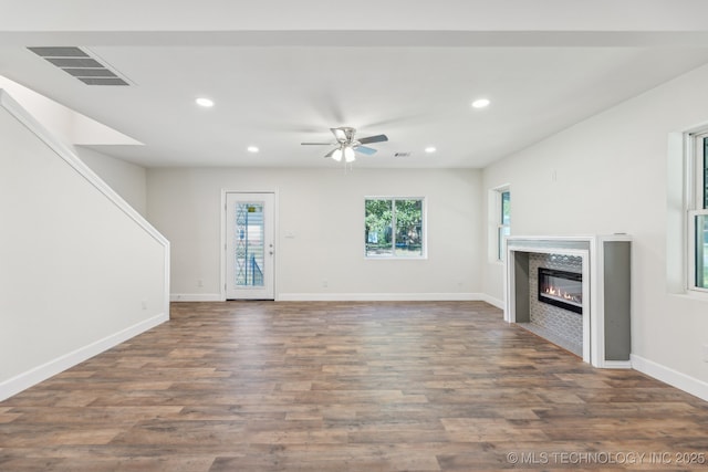1006 N K St, Muskogee, OK 74403 - unfurnished living room featuring recessed lighting, ceiling fan, a glass covered fireplace, and wood finished floors