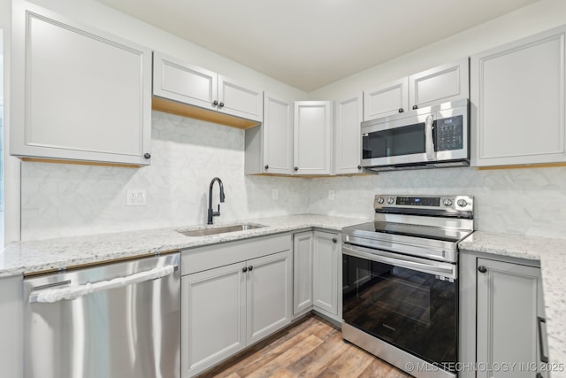 1006 N K St, Muskogee, OK 74403 - kitchen with appliances with stainless steel finishes, light wood-style flooring, backsplash, and light stone countertops