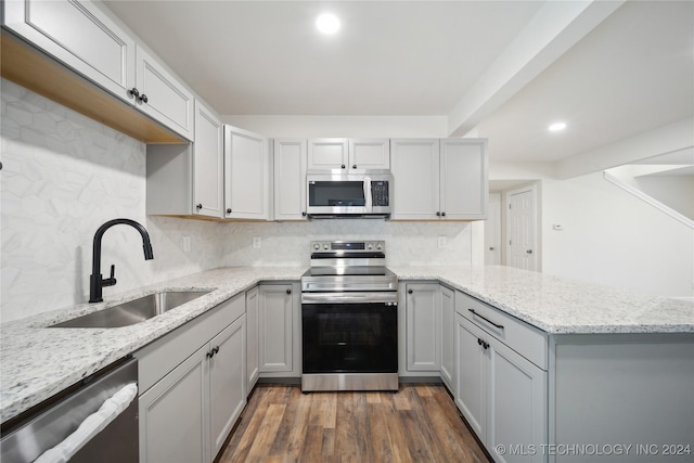 kitchen with backsplash, sink, dark hardwood / wood-style floors, light stone countertops, and stainless steel appliances