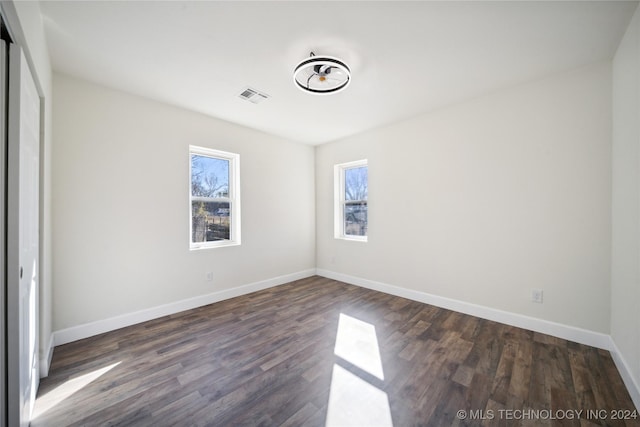 unfurnished bedroom with dark wood-type flooring and a closet