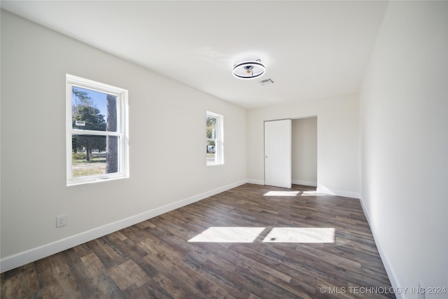 unfurnished room with dark wood-type flooring