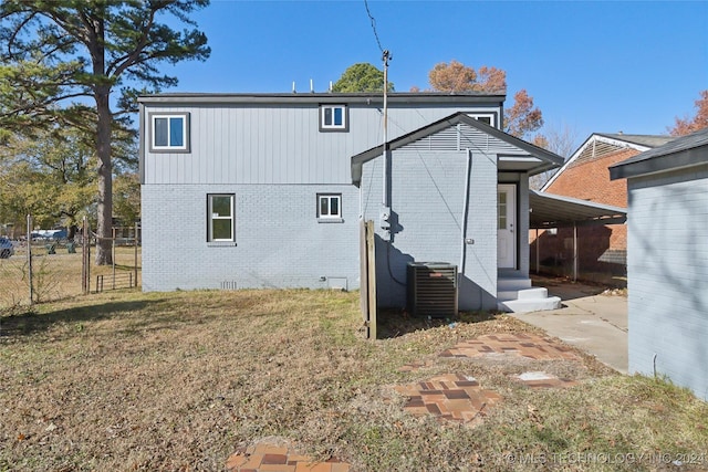 rear view of house featuring a yard, central AC, and a carport