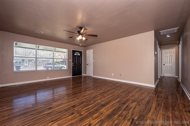 unfurnished living room with dark hardwood / wood-style flooring and ceiling fan