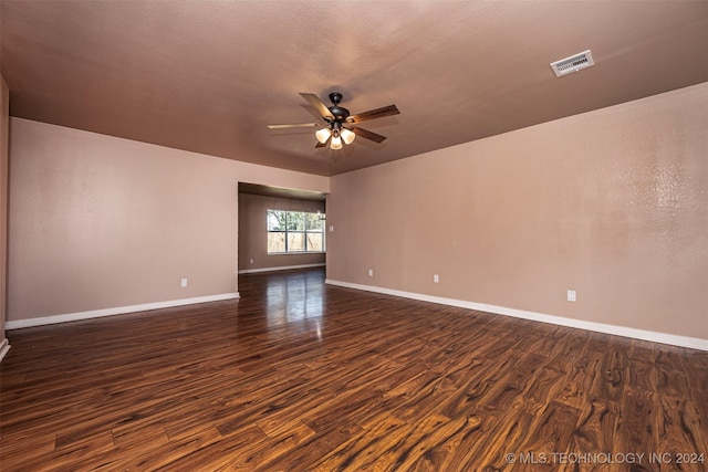 empty room with ceiling fan, dark hardwood / wood-style flooring, and a textured ceiling