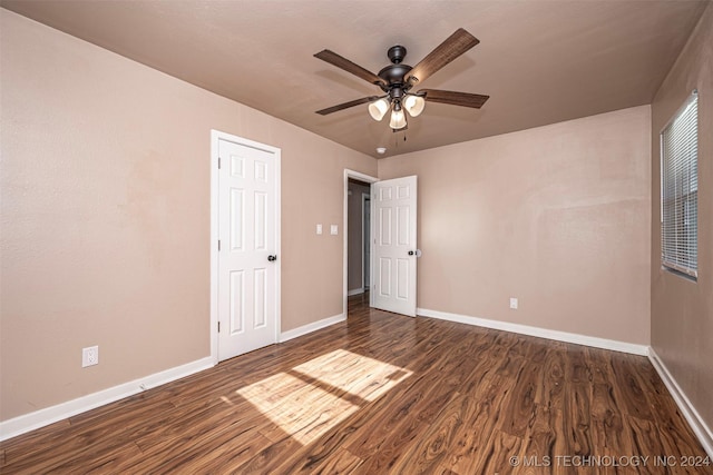 unfurnished bedroom featuring ceiling fan and dark wood-type flooring