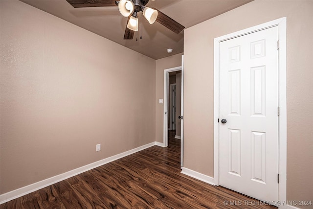 unfurnished bedroom featuring ceiling fan and dark hardwood / wood-style flooring