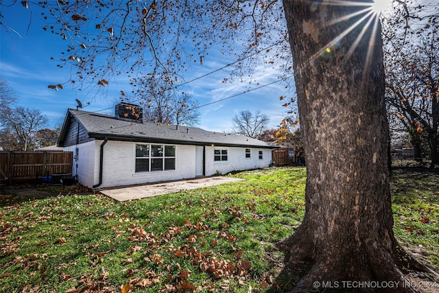 rear view of property featuring a patio area and a yard