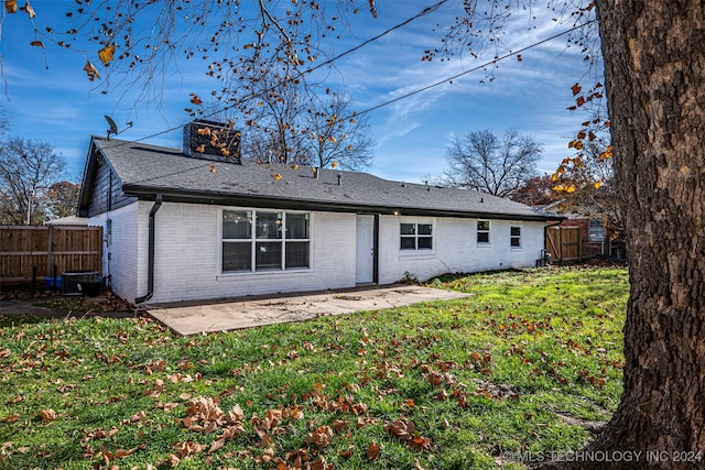 rear view of property featuring central AC unit, a storage unit, a patio area, and a yard