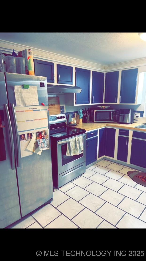 kitchen with light tile patterned floors, stainless steel appliances, sink, and blue cabinets