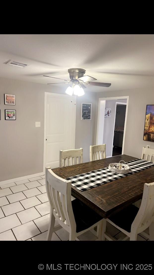 tiled dining space with ceiling fan