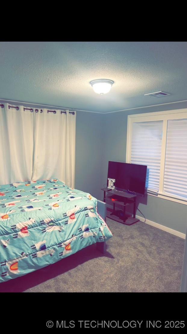 bedroom with a textured ceiling and carpet flooring