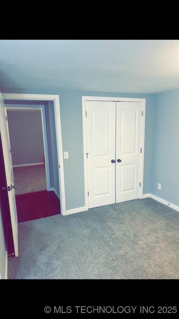 unfurnished bedroom with a closet and carpet flooring