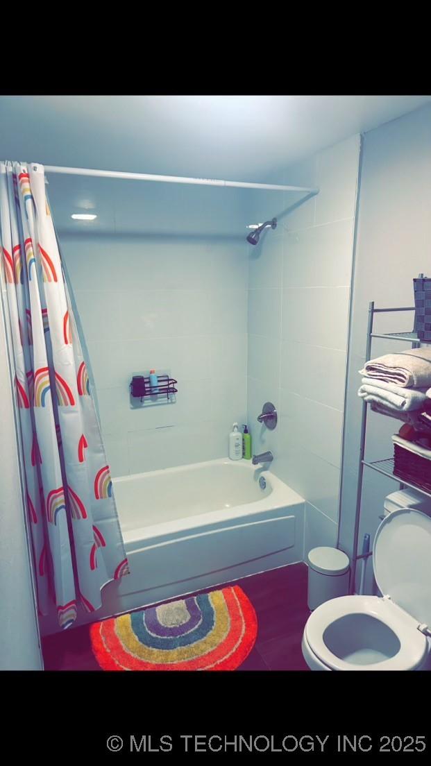 bathroom with shower / tub combo and toilet