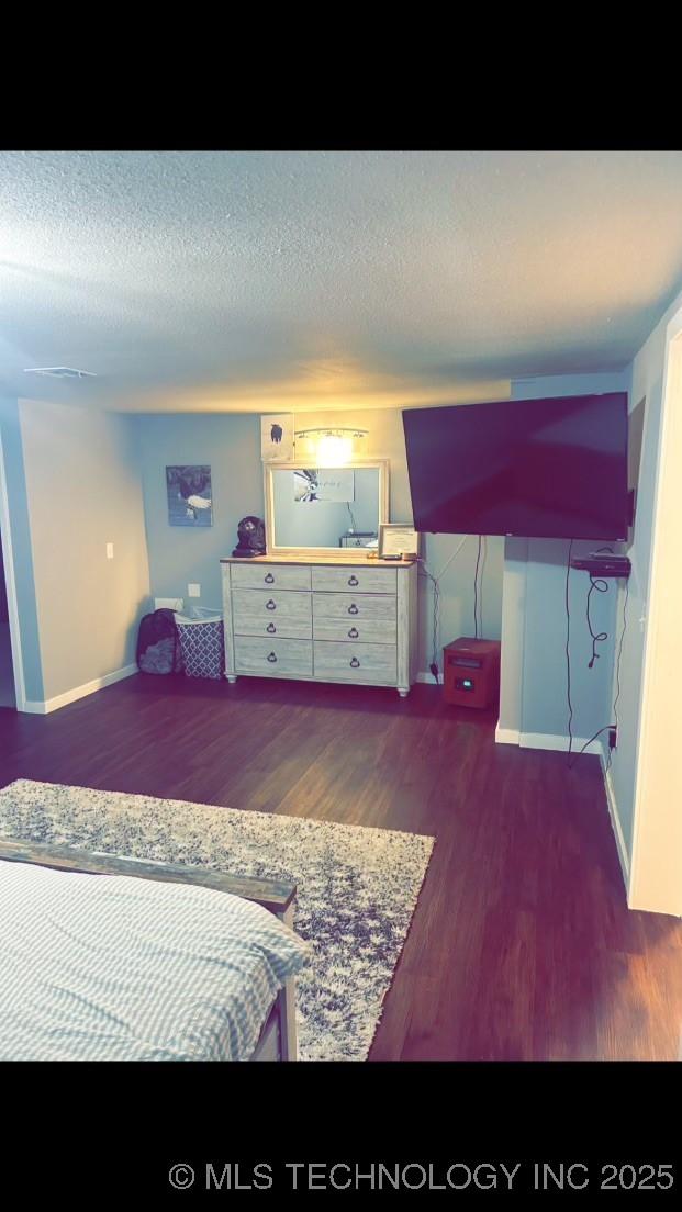 bedroom featuring dark wood-type flooring and a textured ceiling