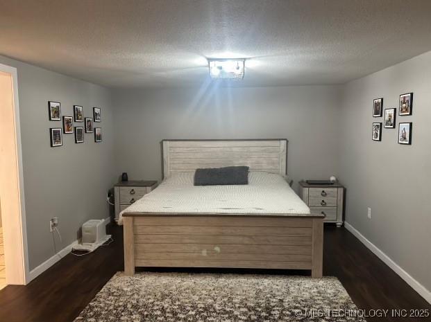 bedroom featuring dark hardwood / wood-style floors and a textured ceiling