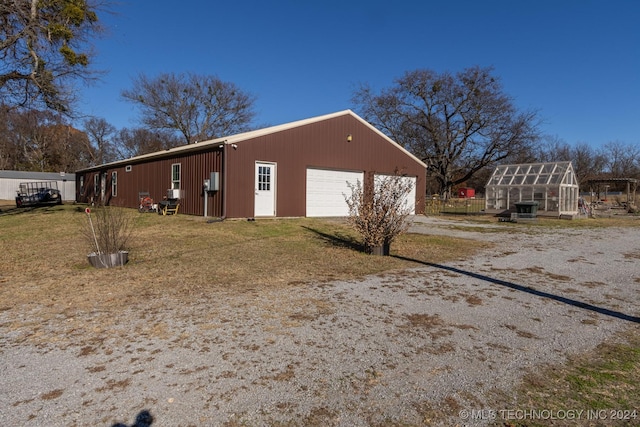 view of side of home with a garage and an outbuilding