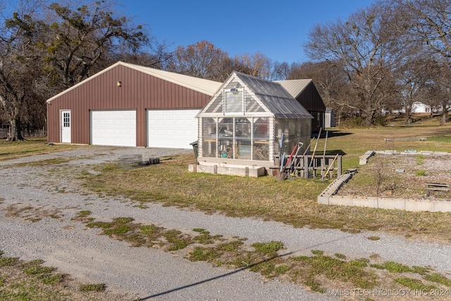 exterior space featuring a garage, a front lawn, and an outdoor structure