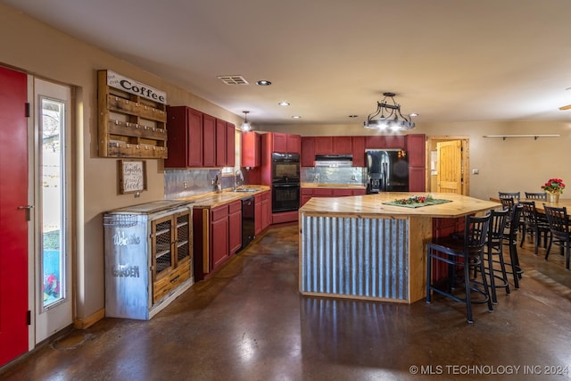 kitchen featuring wood counters, backsplash, plenty of natural light, and black appliances