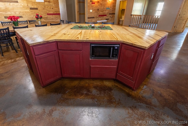 kitchen with wooden counters, a kitchen island, and black appliances