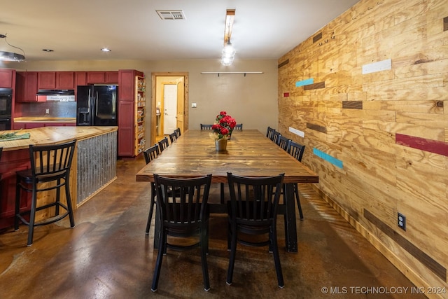 dining room featuring wood walls