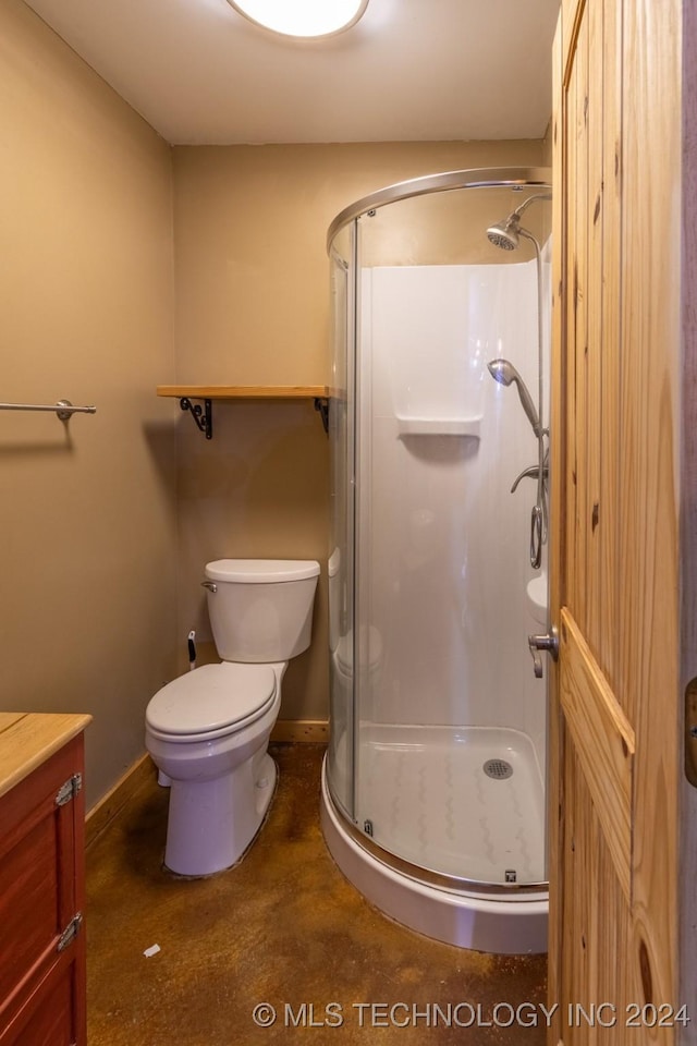 bathroom featuring vanity, toilet, and an enclosed shower