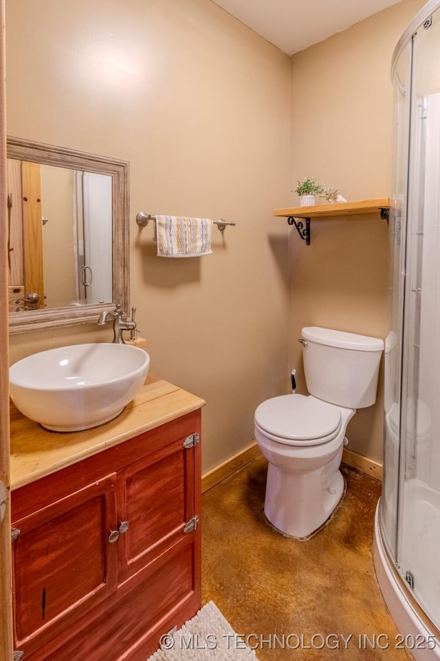 bathroom with vanity, a shower with shower door, and toilet