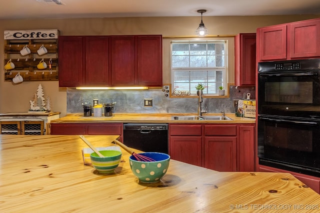 kitchen featuring sink, wooden counters, hanging light fixtures, black appliances, and decorative backsplash