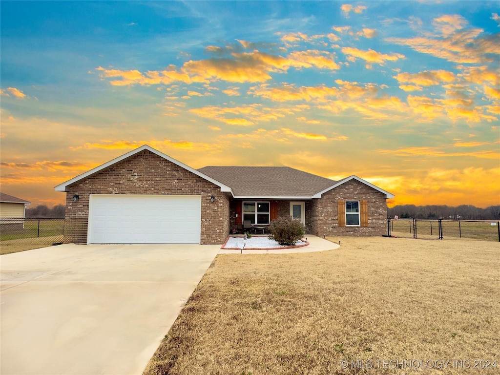 single story home featuring a lawn and a garage