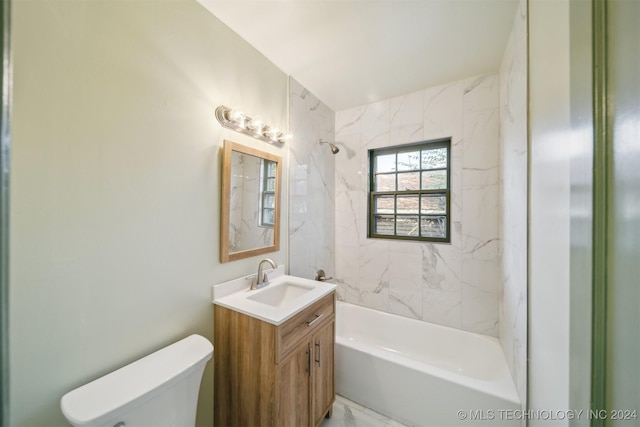 full bathroom featuring tiled shower / bath, vanity, and toilet