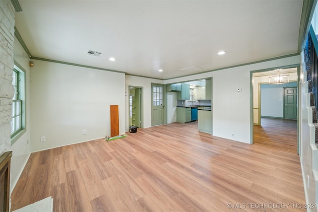 unfurnished living room featuring a healthy amount of sunlight, crown molding, and light hardwood / wood-style flooring