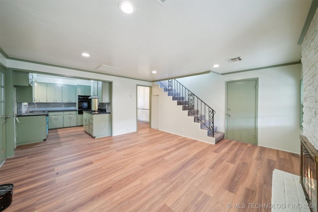 unfurnished living room featuring light hardwood / wood-style floors and ornamental molding