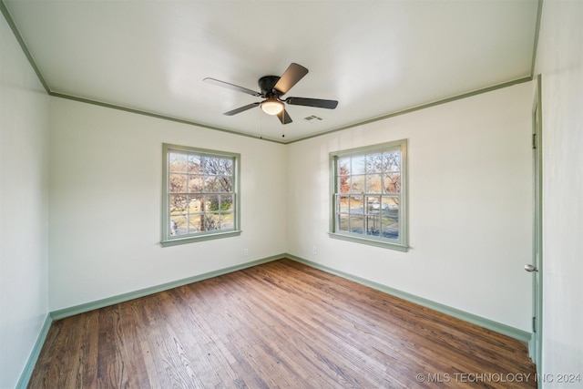 empty room with ceiling fan, plenty of natural light, and dark wood-type flooring